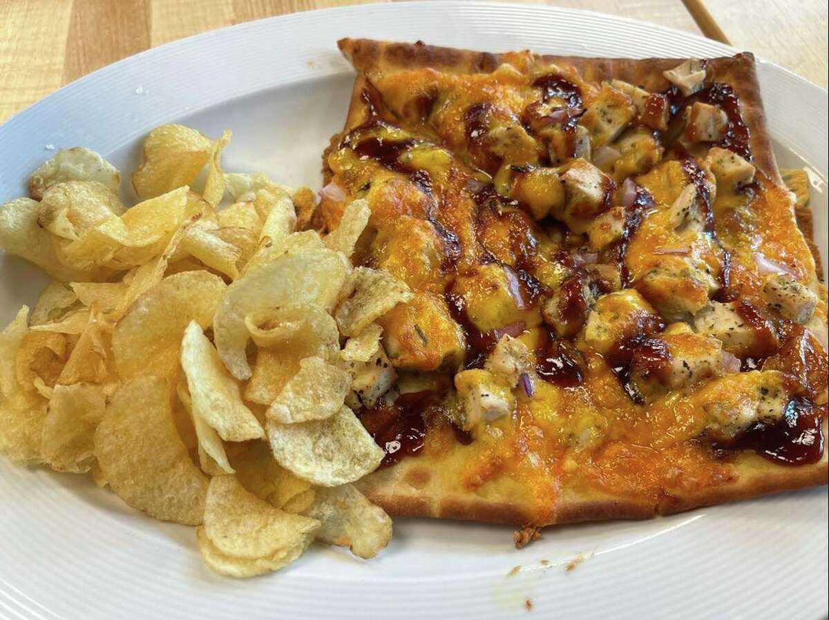 The barbecue chicken flatbread at State Street Café includes chicken, onions, cheddar cheese and a savory barbecue sauce. The lunch is accompanied by a side of chips.