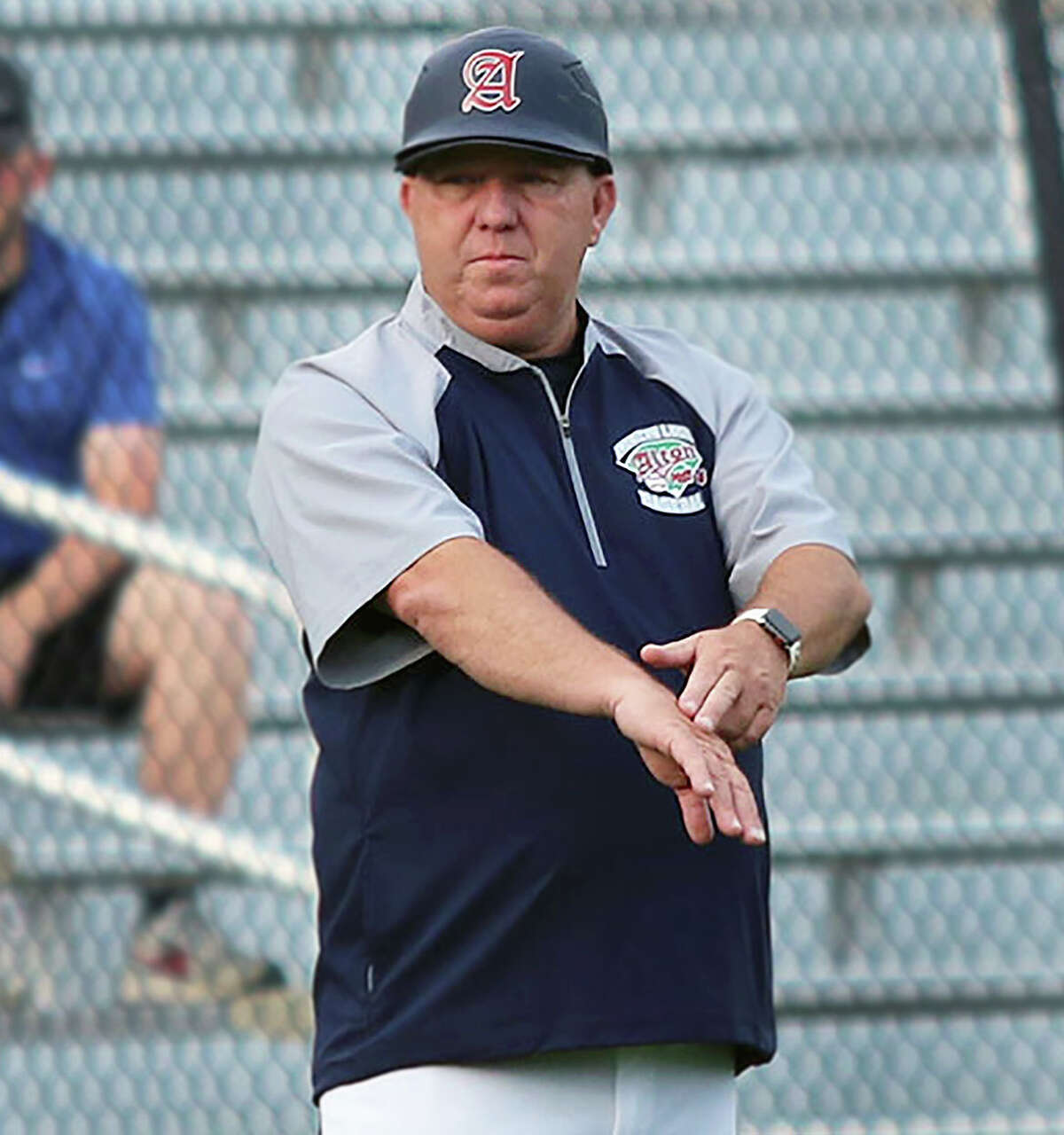 Alton Post 26 manager Doug Booten gives signals during District 22 action against Highland.