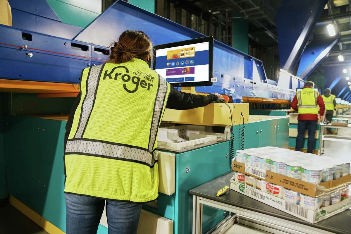 Workers prepare orders at a Kroger customer fulfillment hub.