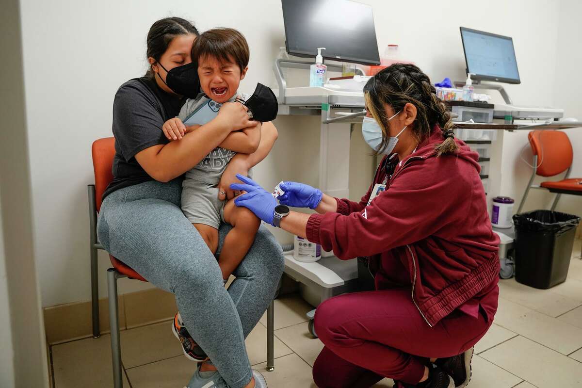 Ezra Von Allnen 4, reacts to getting a COVID vaccine from University Health’s medical assistant Michelle Robledo in downtown San Antonio.