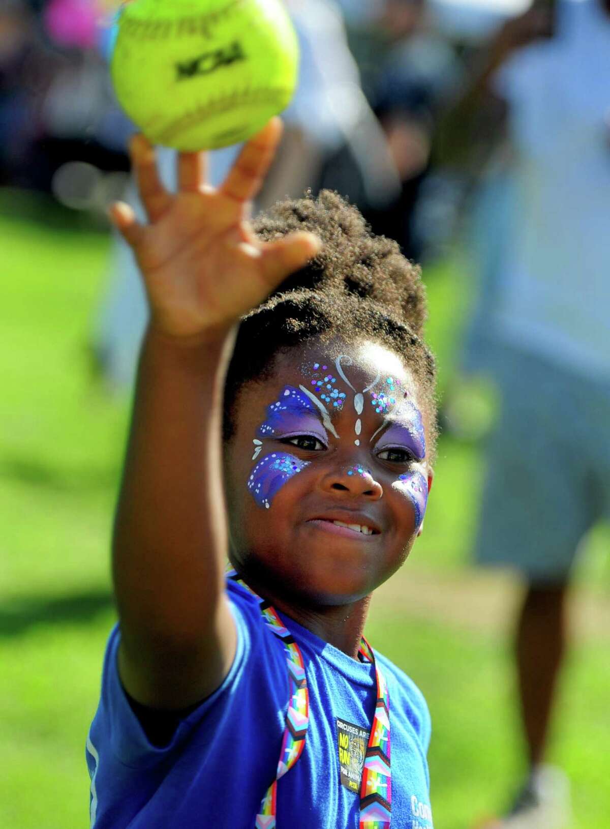 Kaidence Wallace, 8, throws a softball to try and dunk a police officer during Stamford Police Department's annual National Night Out event at Latham Park in Stamford, Conn., on Tuesday August 2, 2022. The event is a "crime prevention program" that emphasizes building stronger partnerships between the community and the department.
