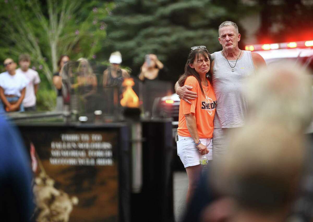 Mary Graft and John Sandor, parents of deceased Navy sailor Xavier Sandor, are overcome with emotion during a visit by the Tribute to Fallen Soldiers Memorial Torch Motorcycle Ride to their home in Shelton on Tuesday.