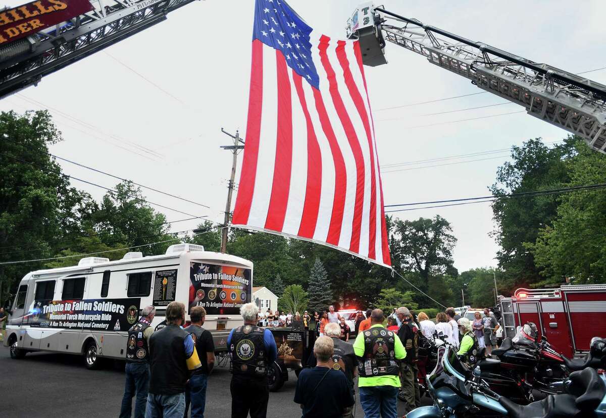 A visit by the Tribute to Fallen Soldiers Memorial Torch Motorcycle Ride holds a ceremony for the family of deceased Navy sailor Xavier Sandor near their home in Shelton, Conn. on Tuesday, August 2, 2022.