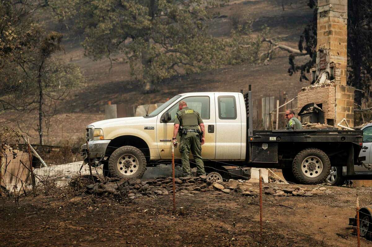 2022年8月2日星期二，加利福尼亚州克拉马斯国家森林，麦金尼大火发生后，警长的副手搜查了一处烧焦的住宅。