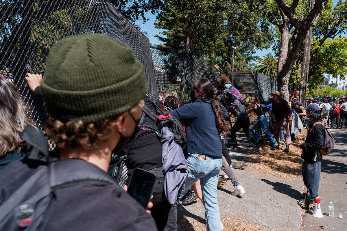 Los manifestantes intentan derribar una valla en People's Park en Berkeley, California, el miércoles 3 de agosto de 2022.