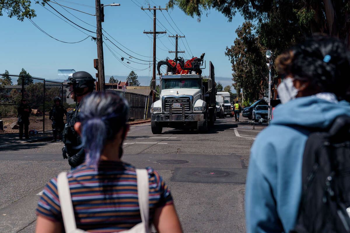La gente impide que los contratistas y su equipo utilizado para talar árboles salgan del People's Park en Berkeley, California, el miércoles 3 de agosto de 2022.
