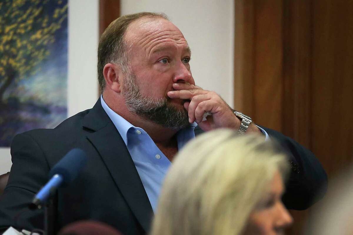 Alex Jones attempts to answer questions about his text messages asked by Mark Bankston, lawyer for Neil Heslin and Scarlett Lewis, during trial at the Travis County Courthouse in Austin, Wednesday Aug. 3, 2022. Jones testified Wednesday that he now understands it was irresponsible of him to declare the Sandy Hook Elementary School shootings a hoax and that he now believes it was “100% real.”