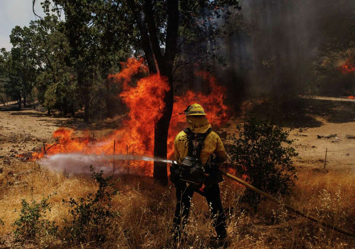 A firefighter battles the Oak Fire in unincorporated Mariposa County.