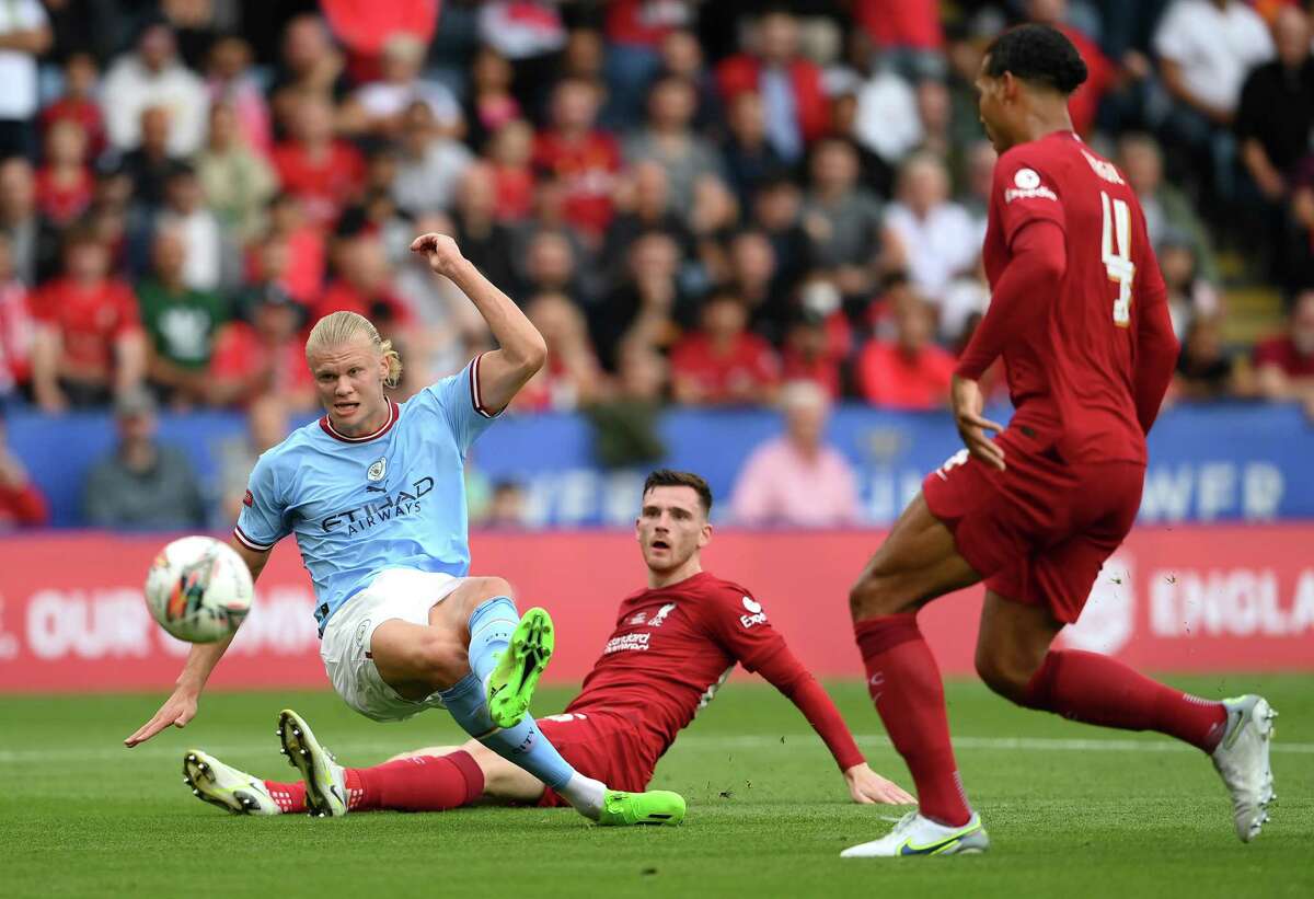 Liverpool defender Andy Robertson, center, looks on as Manchester City forward Erling Haaland shoots while under pressure from Liverpool defender Virgil van Dijk during Liverpool’s 3-1 win in the FA Community Shield at The King Power Stadium on July 30, 2022 in Leicester, England. Manchester City won the 2021-22 Premier League title, one point ahead of second-place Liverpool. Stamford-based NBC Sports is the exclusive U.S. media home of the Premier League, whose 2022-23 season starts on Friday, Aug. 5, 2022.