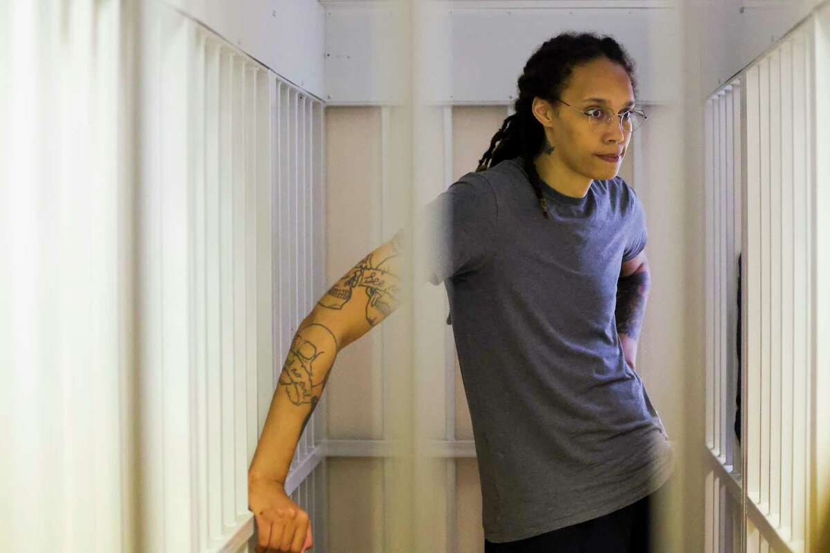 WNBA star and two-time Olympic gold medalist Brittney Griner stands listening to Thursday's verdict in a courtroom in Khimki, Russia, just outside Moscow.