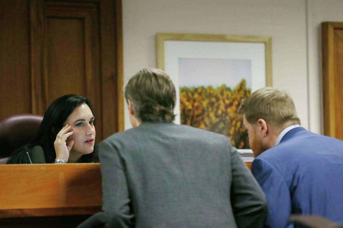 Judge Maya Guerra Gamble has a private conversation with Andino Reynal, lawyer for Alex Jones, and Mark Bankston, lawyer for Neil Heslin and Scarlett Lewis, during a trial at the Travis County Courthouse, Wednesday Aug. 3, 2022, in Austin, Texas.  (Briana Sanchez/Austin American-Statesman via AP)