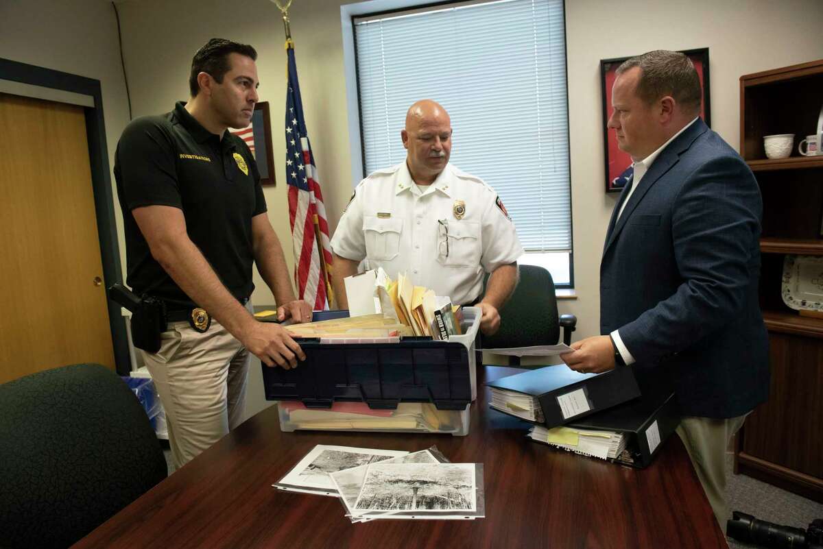 From left, Colonie Sgt. John Santorio, Colonie Deputy Chief Robert Winn and Colonie Lt. Daniel Belles look through evidence from a cold case that happened in 1959 on Tuesday, Aug. 2, 2022, in Colonie, N.Y. Colonie Police recently exhumed the body of Ruth Whitman from a decades-old killing.