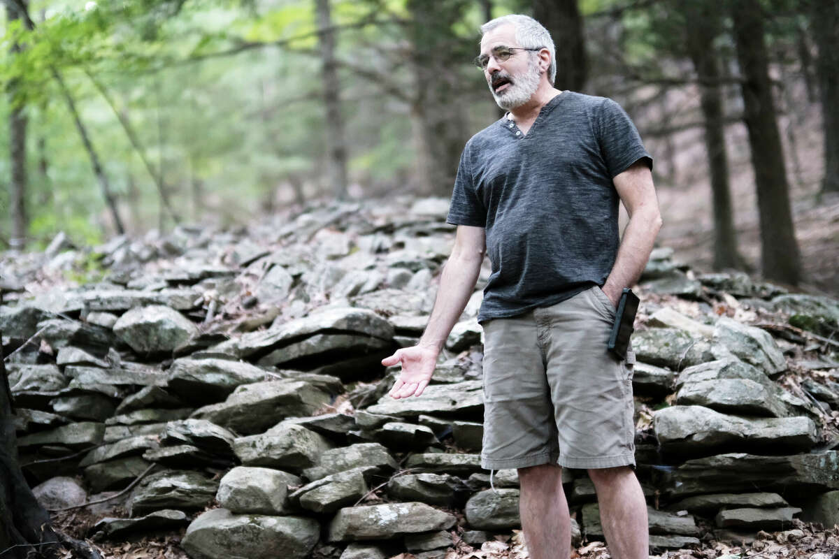 Glenn Kreisberg in front of one of the eight "great cairns" found on the site, masses of stacked rock 60-100 feet long.