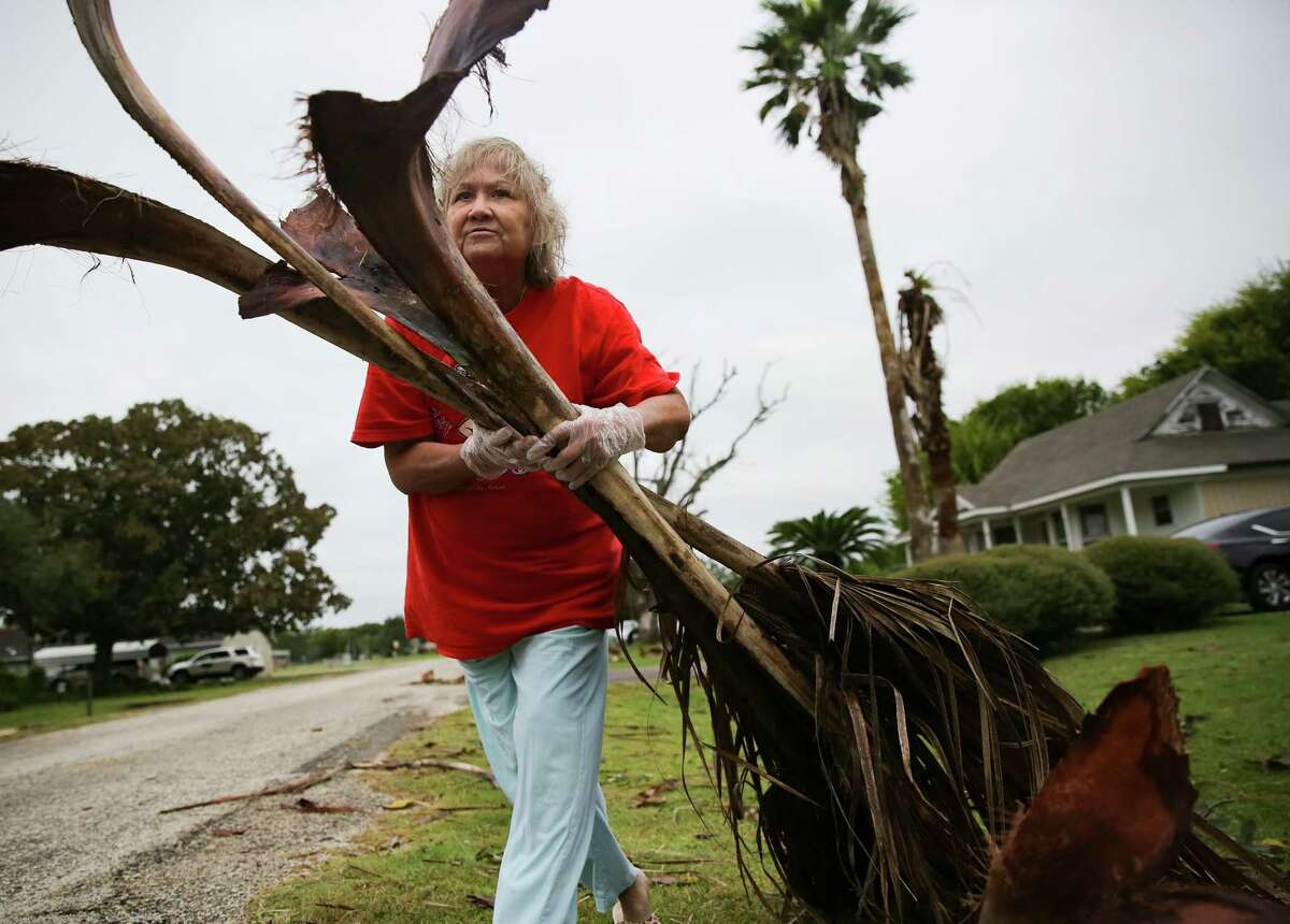 Alfa Alamia cleans up her brother's yard in Palacios following Hurricane Nicholas on Sept. 14, 2021. Alamia has lived in Palacios since she was 12.