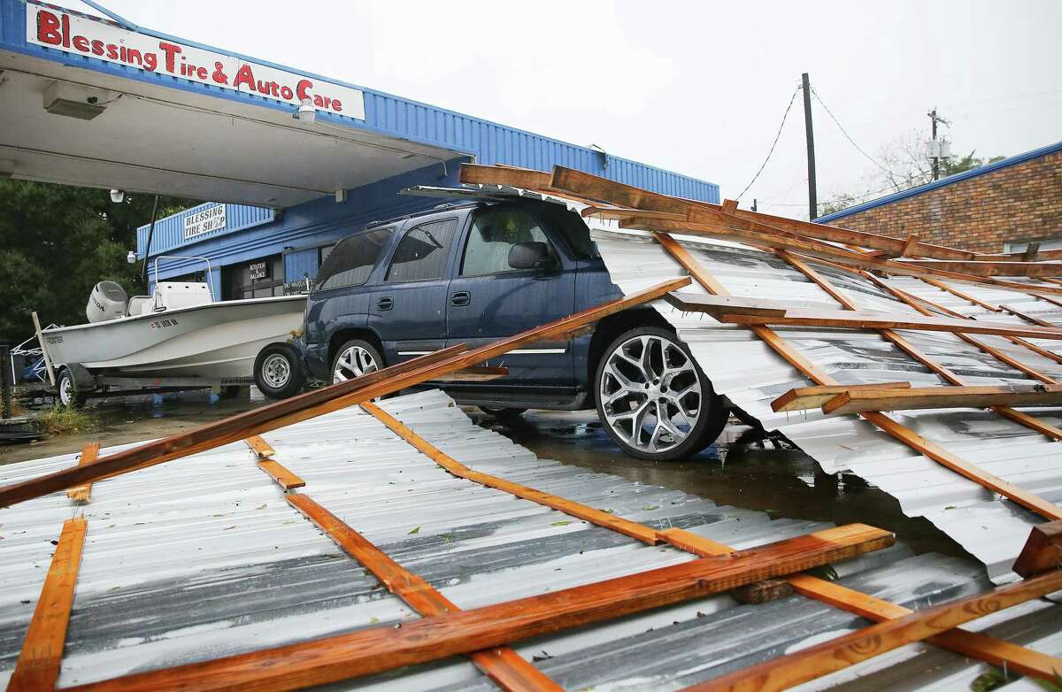 A roof on top of a car parked at Blessings Tire and Auto Care following Hurricane Nicholas in Bay City on Sept. 14, 2021. According to the owner of the business, he wasn't sure where the roof came from.