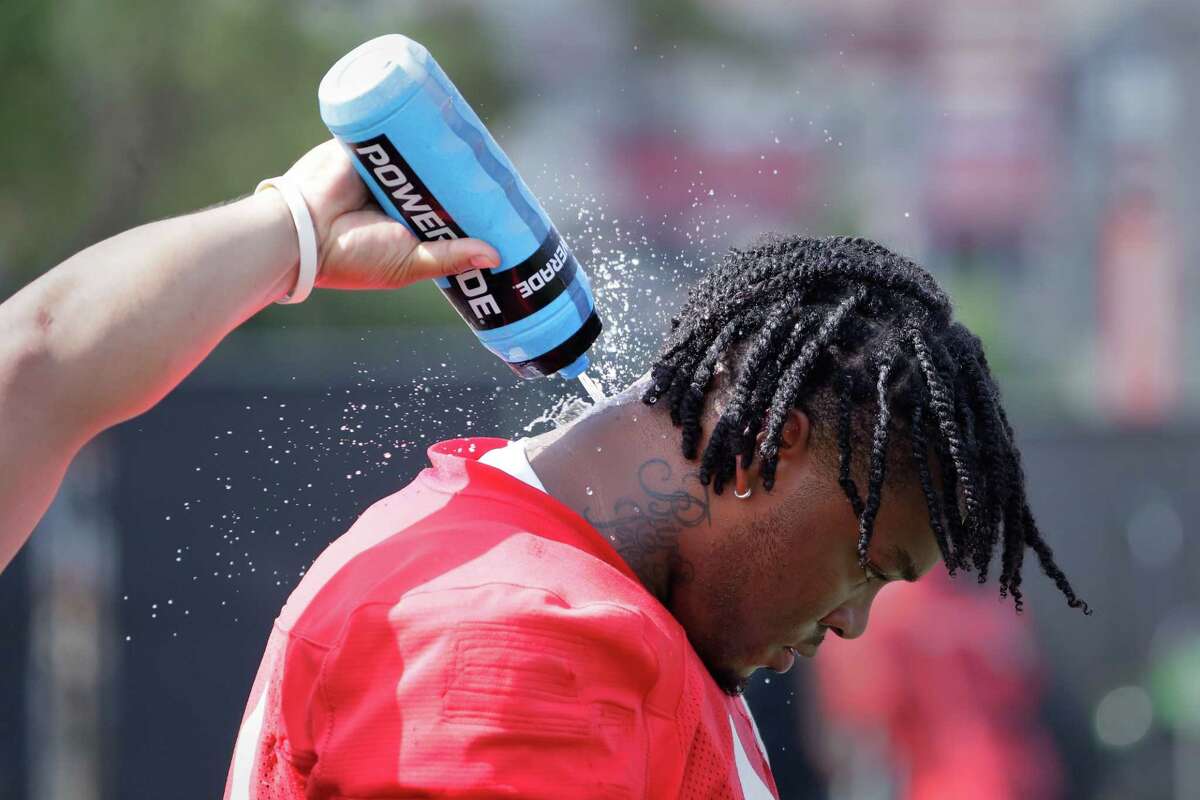 Houston Cougars defensive lineman D’Anthony Jones gets water squirted on his neck during a break on the first day of football practice at the University of Houston campus facilities Thursday, Aug. 4, 2022 in Houston, TX.
