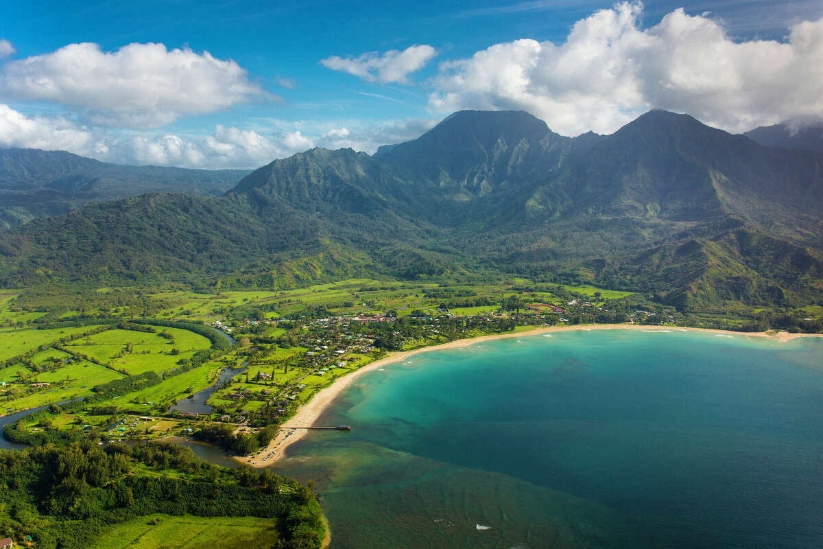 The town of Hanalei, with Hanalei Beach and Bay visible on the coast, are seen from the sky over Hawaii's island of Kauai.
