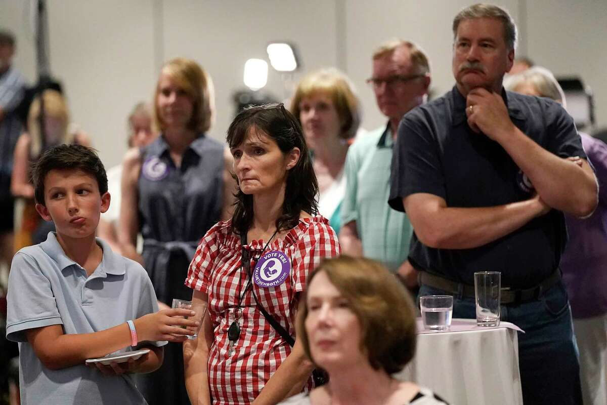 People listen as organizers speak during a Value Them Both watch party after a question involving a constitutional amendment removing abortion protections from the Kansas constitution failed, Tuesday, Aug. 2, 2022, in Overland Park, Kan. (AP Photo/Charlie Riedel)