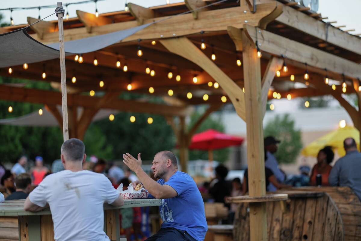 WestSide Square guests enjoy food and drinks under a pergola on the Farmington Avenue food truck property.
