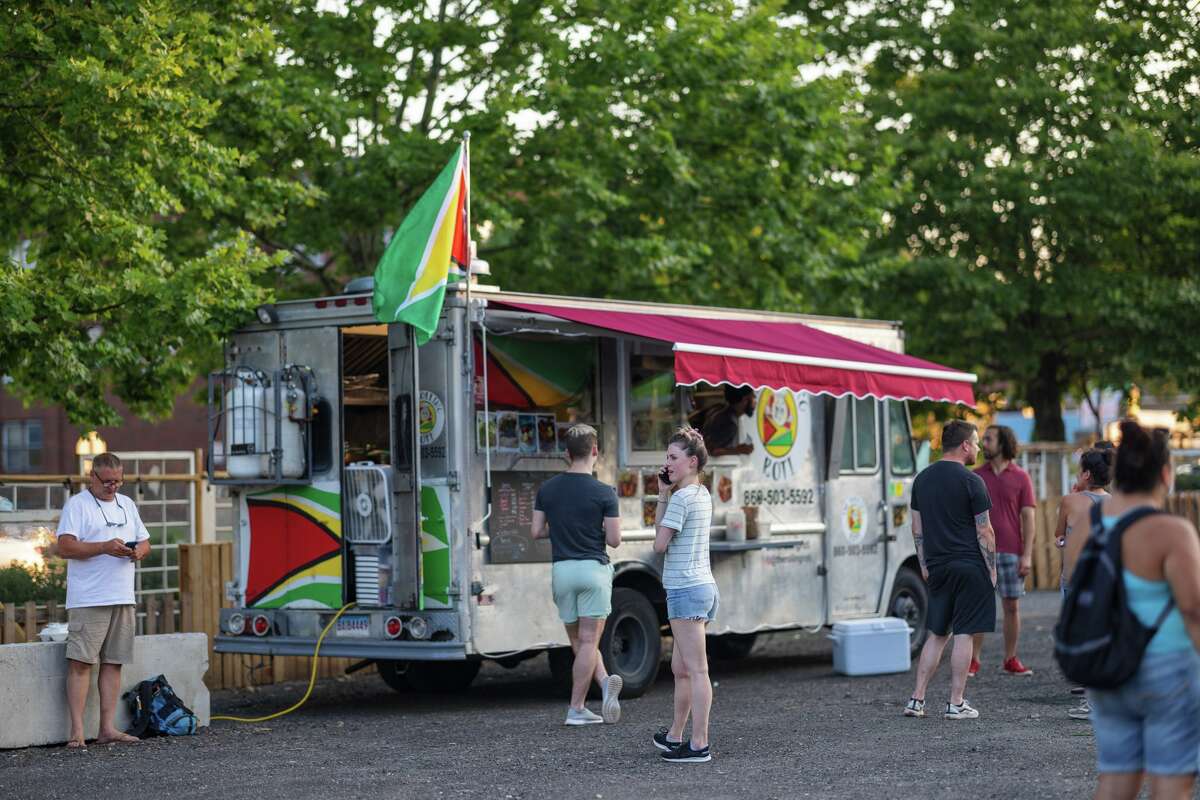 Guests order from the Rolling Roti Guyanese food truck at WestSide Square, Hartford's new food truck park on Farmington Avenue.