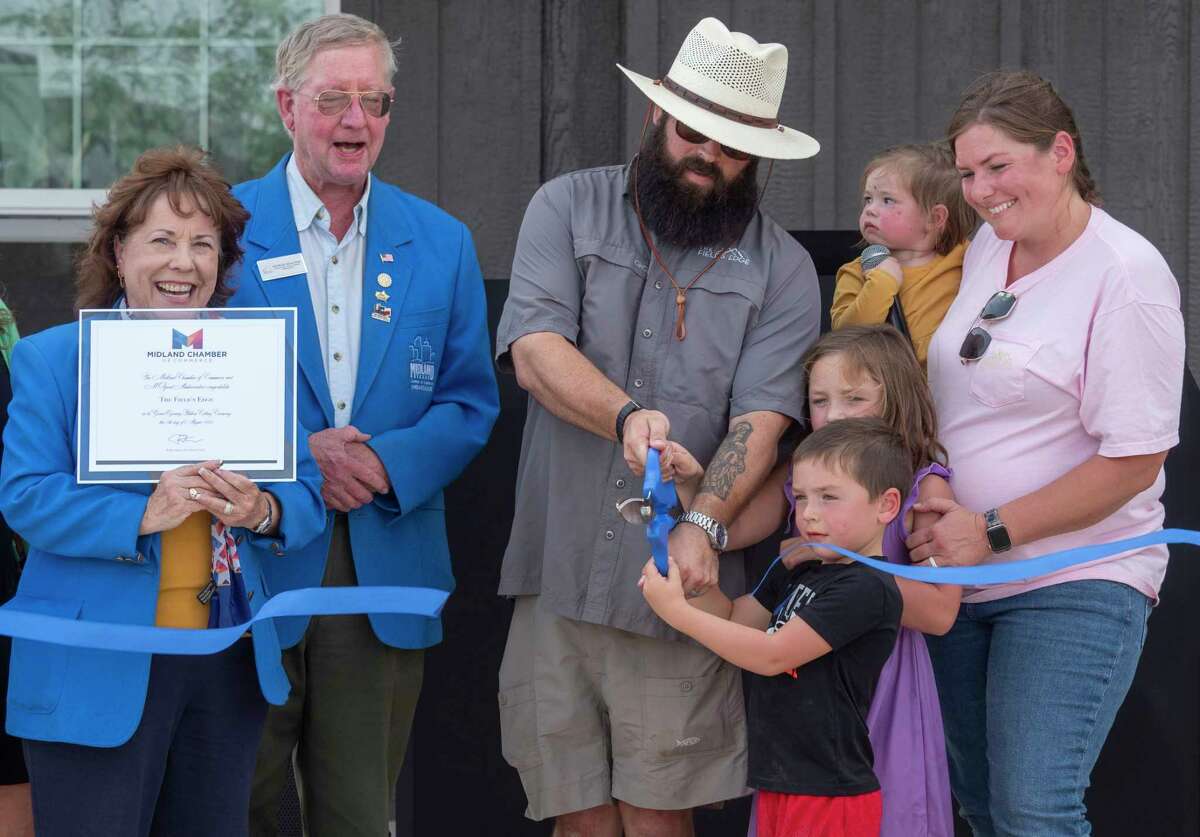 John-Mark and Briana Echols and their children cut the ribbon with members of the Midland Chamber of Commerce during an open house 8/04/2022 to show off the new village area designed to house some of the homeless population in the area. Tim Fischer/Reporter-Telegram