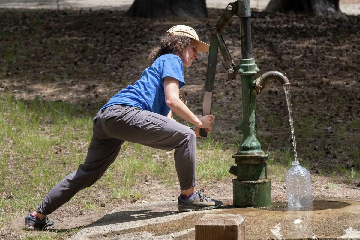 Nina Gordon-Kirsch pumps water from a well at Bloomfield Campground. Gordon-Kirsch, of Oakland, finished her hike and kayak of the whole Mokelumne River from Oakland to its headwaters in the Sierra, Friday, July 29, 2022.