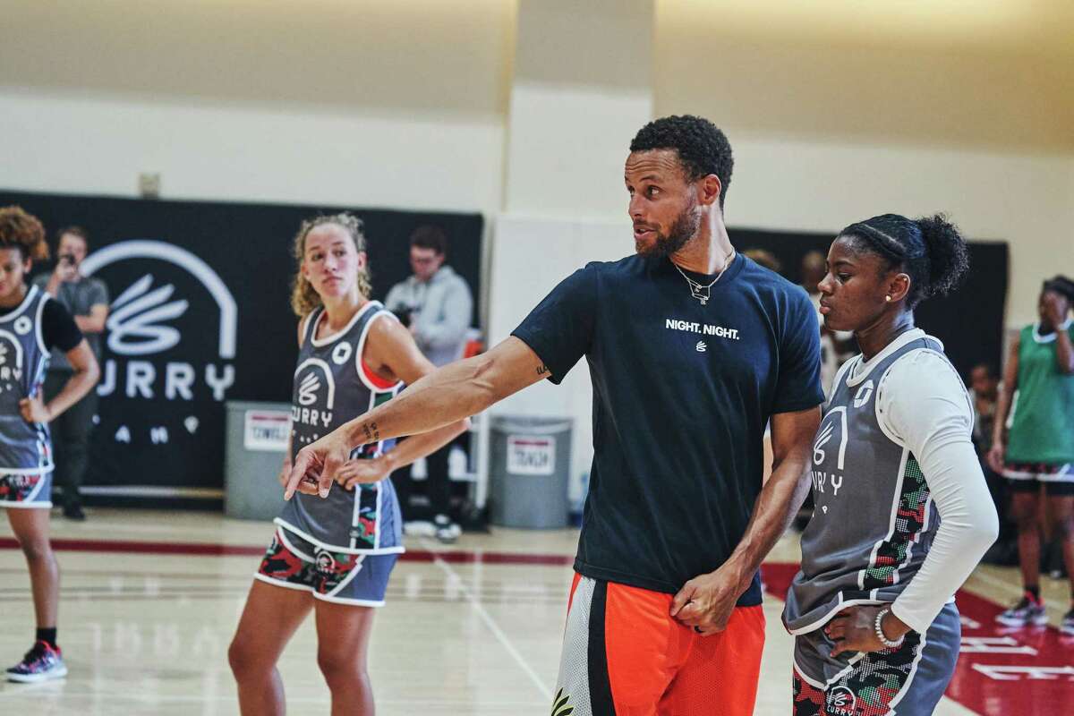 Stephen Curry, points guard for the Golden State Warriors, works with children during Curry's camp at the San Francisco Olympic Club in San Francisco, California on Thursday, August 4, 2022.