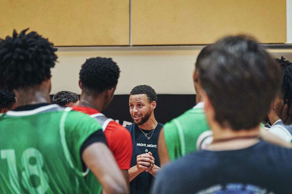 Stephen Curry, points guard for the Golden State Warriors, works with children during Curry's camp at the San Francisco Olympic Club in San Francisco, California on Thursday, August 4, 2022.