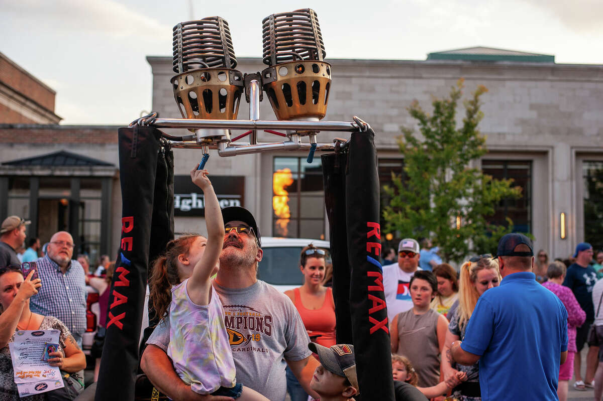 Midland residents Paul Rickard and Elorie Bruc, 6, shoot towers of flames into the air during Main Street Glow on August 4, 2022 at Downtown Midland.