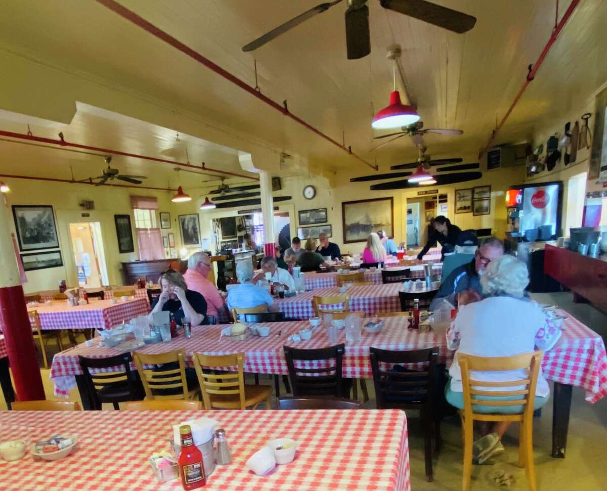 Las mesas altas de madera en Samoa Cookhouse están cubiertas con un hule a cuadros.