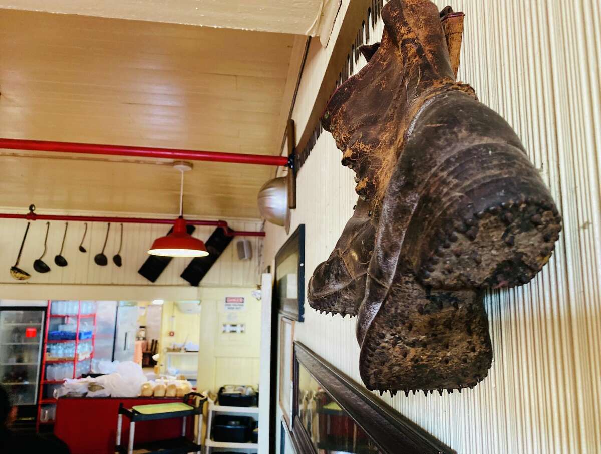 Un viejo par de botas de leñador saluda en una pared en Samoa Cookhouse.