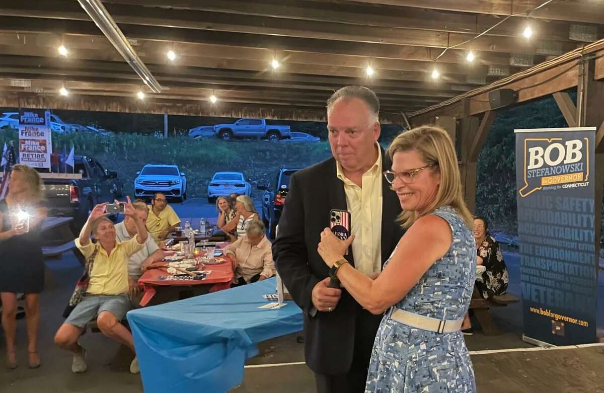 Wills Pike, the master of ceremonies at the Montville Republican Town Committee barbecue, and Leora Levy, who is vying for the Republican nomination to take on U.S. Sen. Richard Blumenthal, listen as Donald Trump speaks on Levy's phone Thursday to offer his endorsement.