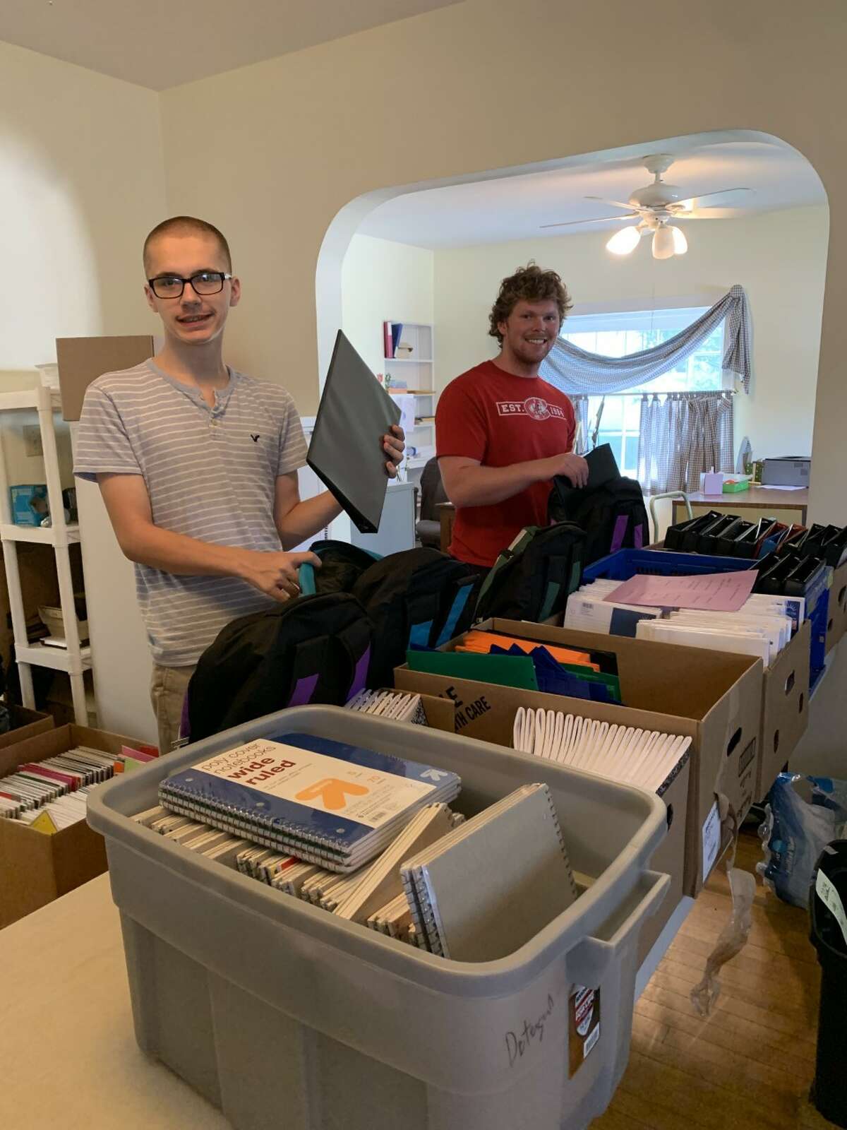 Manna Pantry volunteers fill backpacks for the back to school backpack giveaway. School supplies are free to clients with children in fifth through twelfth grade. Volunteers Zach (left) and Lewis help sort supplies and fill backpacks.