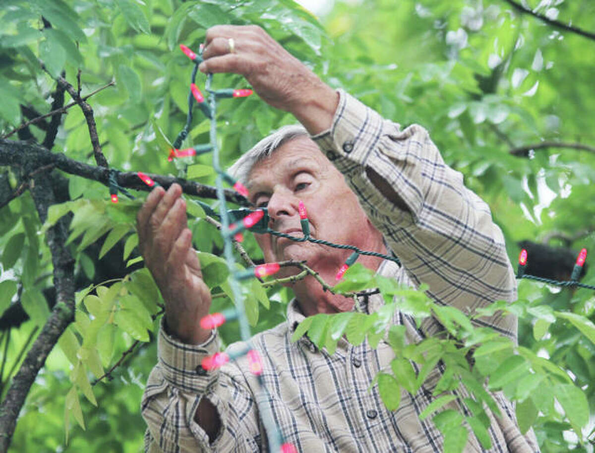John Badman Grandpa Gang member Bert Mary hangs red Christmas lights while standing in a bucket truck in Rock Spring Park. A volunteers' meeting for this year's holiday effort is planned Tuesday.