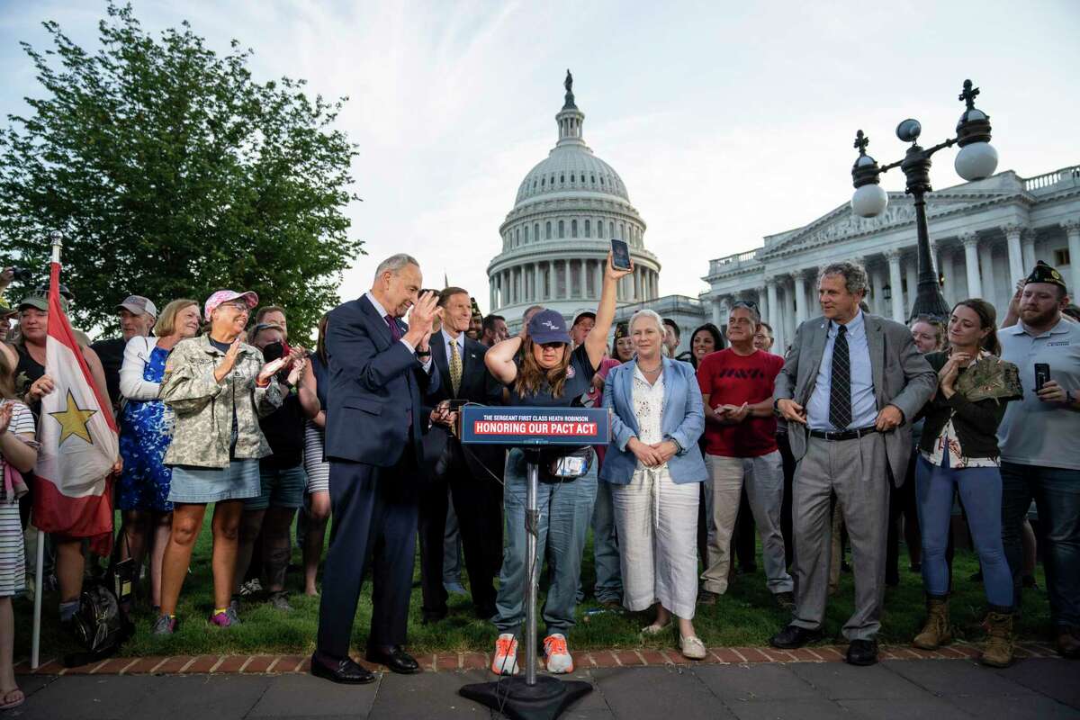 Senate Majority Leader Chuck Schumer applauds as Rosie Torres, wife of veteran Le Roy Torres, who suffers from illnesses related to his exposure to burn pits in Iraq, celebrates the passage of much-needed legislation to serve veterans suffering from toxic exposure.