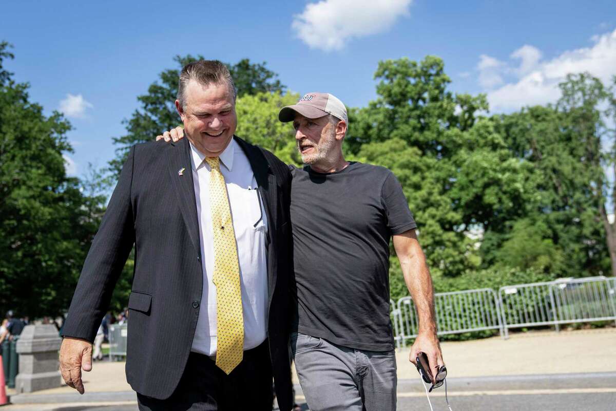 Comedian and activist Jon Stewart puts his arm around Montana Sen. Jon Tester before Congress voted on the PACT Act.