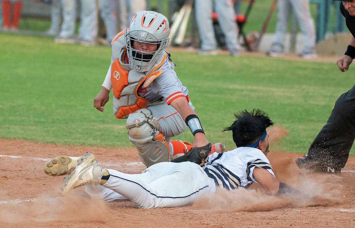 United High School’s Manuel Chaires reaches for the tag as Alexander High School’s Ciro Benavides makes it to home plate, Friday, April 1, 2022 at the UISD Student Activity Complex.