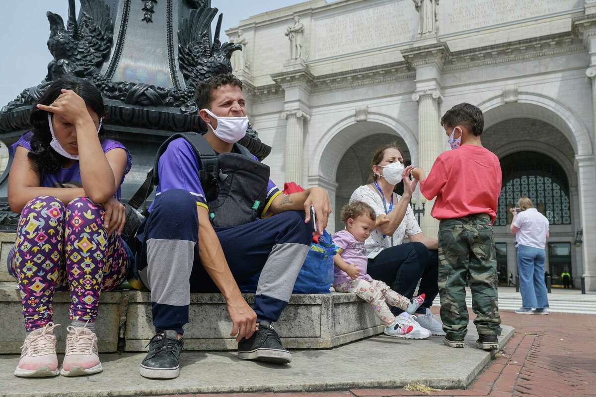 Víctor Rodríguez, 27, and his wife, Ordalis, 26, sit with their children Jeremías, 5, and Luciana, 1, outside the District's Union Station in April. Originally from Venezuela, they were transported via bus from Texas.