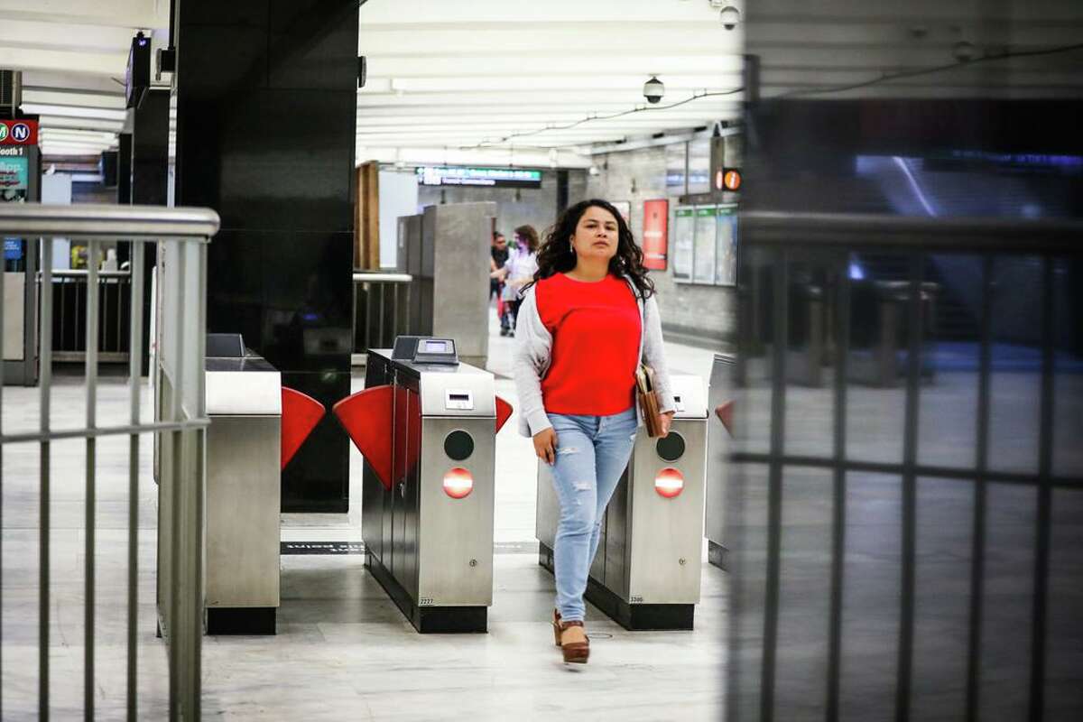 A woman walks into the BART station at Civic Center passing by a newly installed gate (left) that was put in place to deter fare evasion in San Francisco, California, on Thursday, Aug. 16, 2018.
