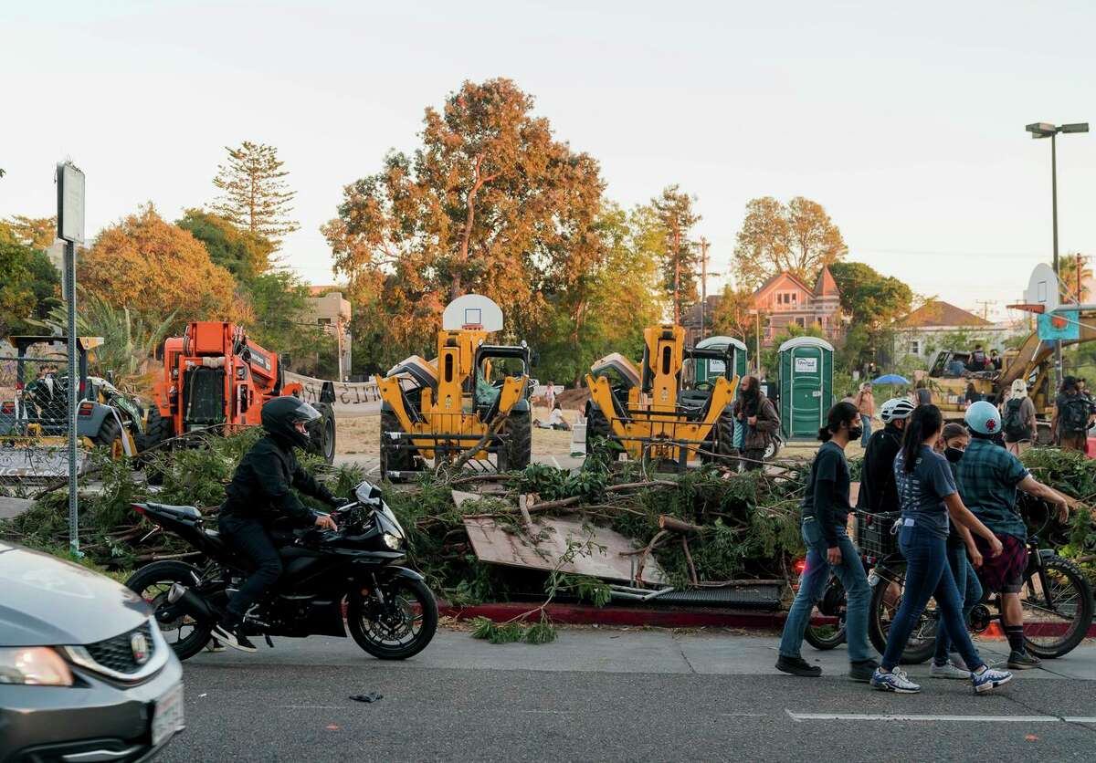 周三，在警察和抗议者就加州大学伯克利分校(UC Berkeley)将该地区改造为学生宿舍的计划发生冲突后，路人检查了人民公园。