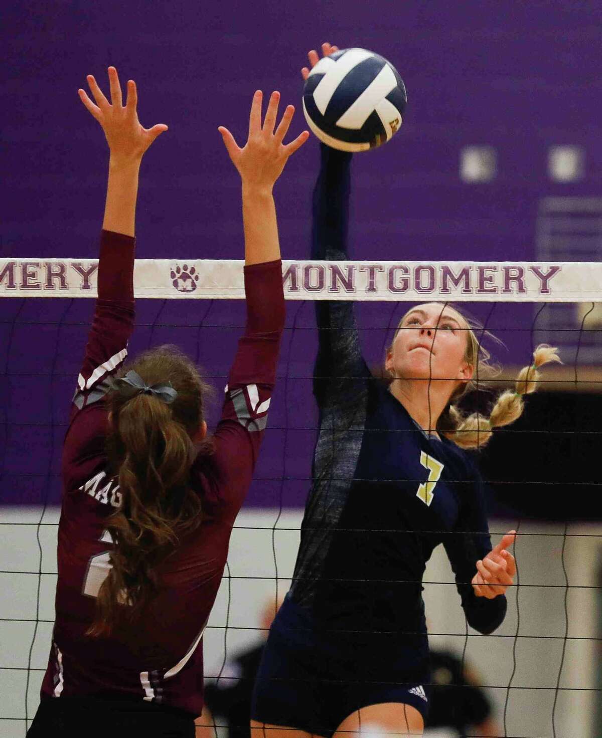 Lake Creek middle blocker Lauren Hilty (7) gets a shot past Magnolia setter Chloe Richards (2) in the first set of a Region III-5A bi-district volleyball playoff match at Montgomery High School, Tuesday, Nov. 2, 2021, in Montgomery.