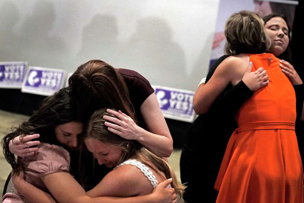 People hug during a "Value Them Both" watch party after a question involving a constitutional amendment removing abortion protections from the Kansas constitution failed, Tuesday, Aug. 2, 2022, in Overland Park, Kan. Abortion rights opponents were shocked and abortion advocates energized by a decisive statewide vote in heavily Republican Kansas this week in favor of protecting abortion access. (AP Photo/Charlie Riedel)