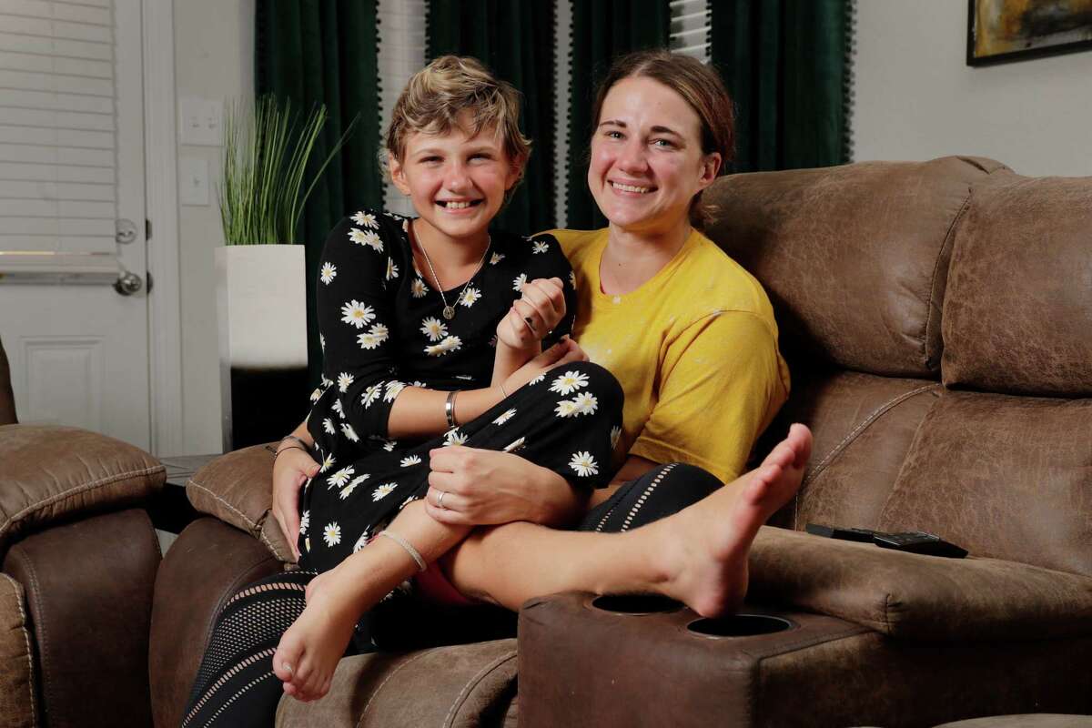 Eight year old Mae Gerdsenwith her mother Kelli Howell in the living room of their home Thursday, Aug. 4, 2022 in Magnolia, TX.