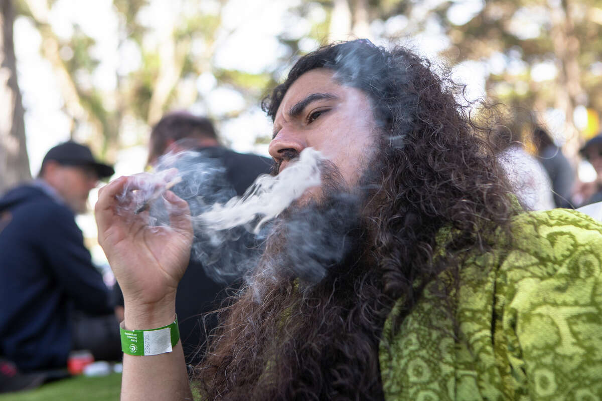 Kevin Alphonso take a hit from a joint at GrassLands at Outside Lands in Golden Gate Park in San Francisco, Calif. on Aug. 5, 2022.