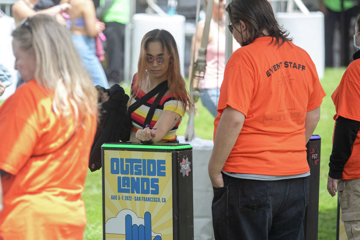 Посетитель фестиваля использует свой значок, чтобы войти во внешние земли в парке Золотые Ворота в Сан-Франциско, Калифорния, 5 августа 2022 года.