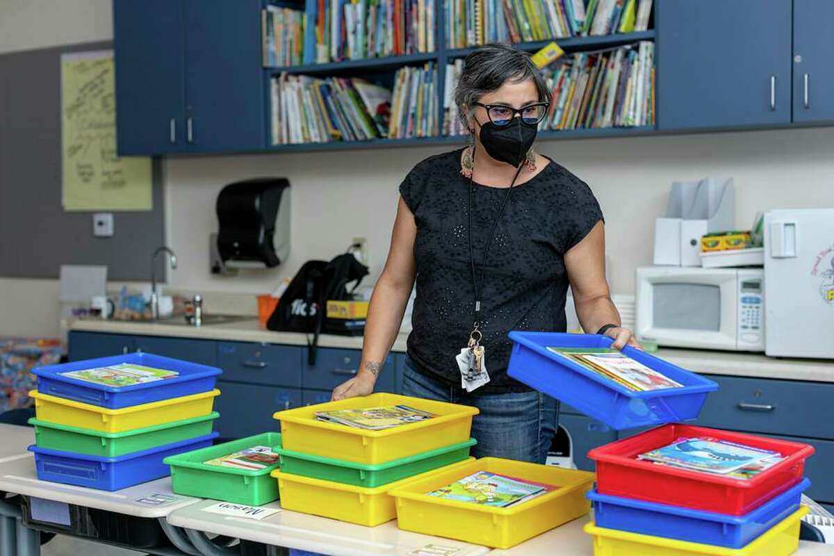 First-grade teacher Carla Aiello organizes books in preparation for opening day at Lincoln Elementary School in Oakland.