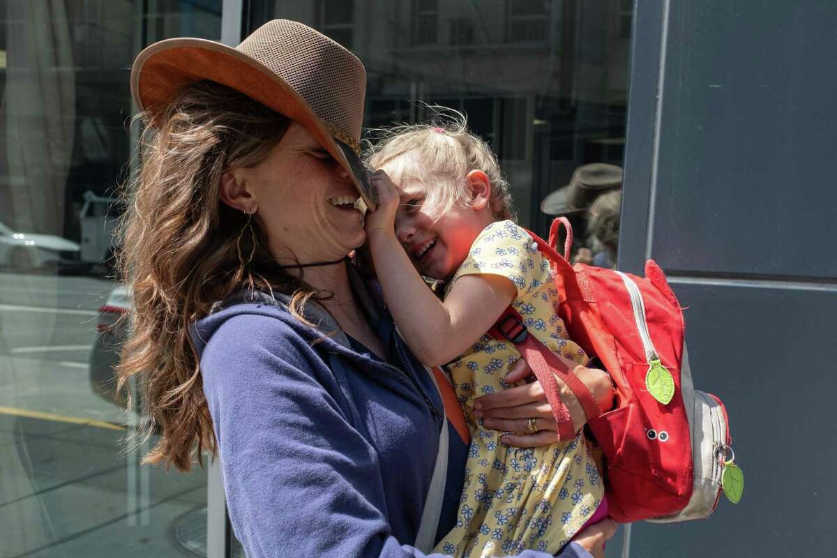 Amanda Collins shares a playful moment with her daughter Isla, 5, after preschool in San Francisco, California on Thursday, August 4, 2022. Collins, a teacher and librarian, is moving from the Palo Alto School District to San Francisco, filling an in a teacher shortage throughout the city.