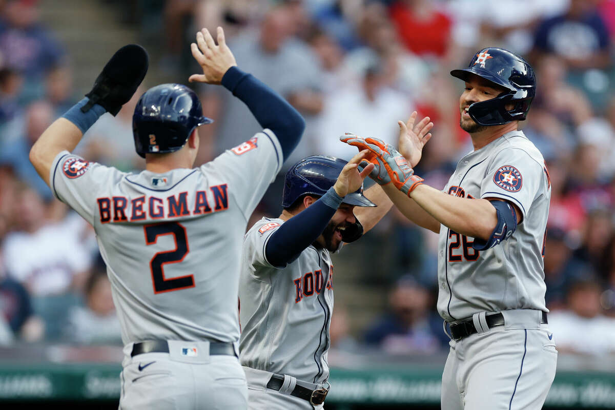 Houston Astros' Trey Mancini (26) celebrates with Jose Altuve and Alex Bregman (2) after hitting a grand slam off Cleveland Guardians starting pitcher Hunter Gaddis during the third inning of a baseball game Friday, Aug. 5, 2022, in Cleveland. (AP Photo/Ron Schwane)