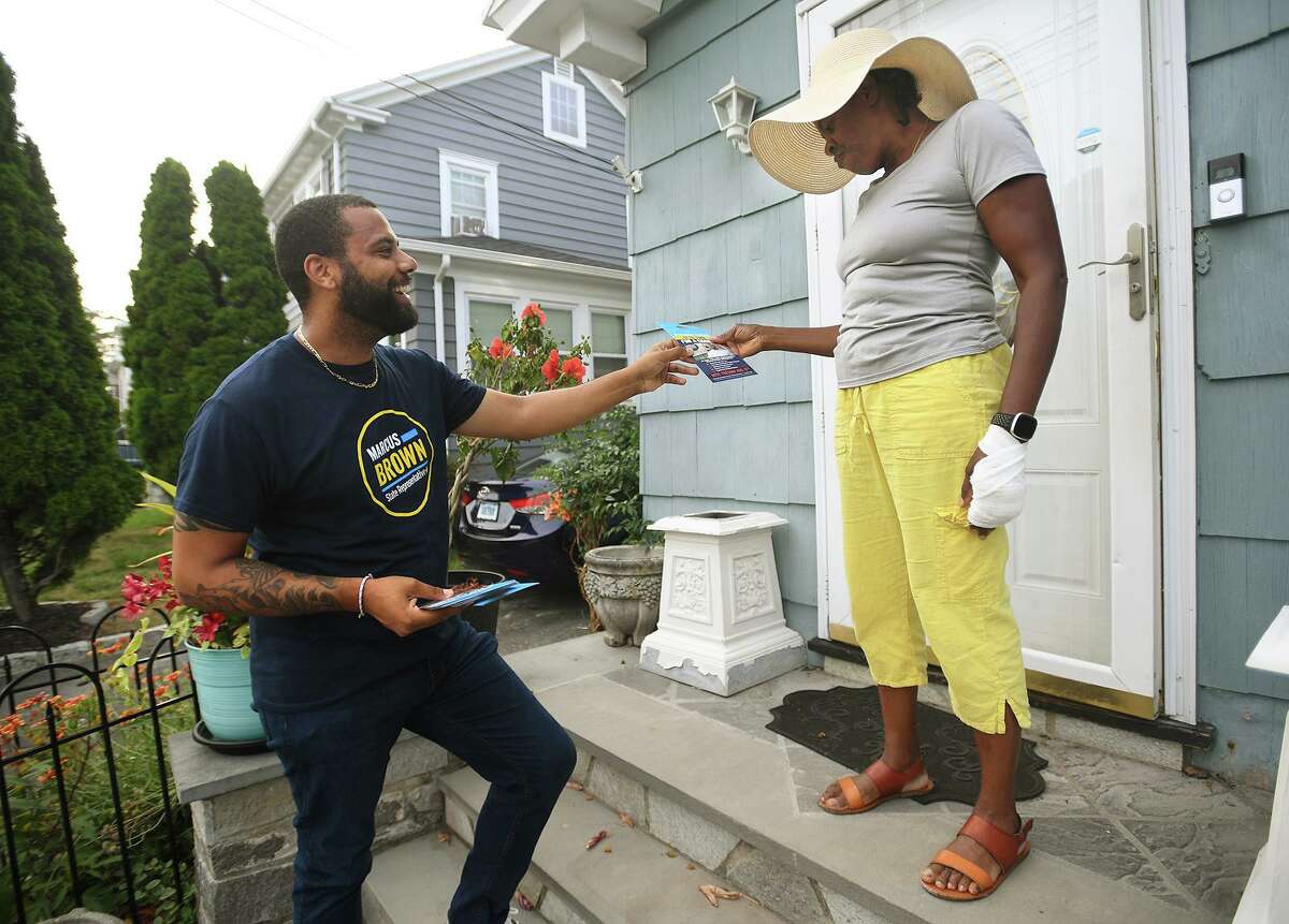 Campaigning for the Democratic primary for district 127 state representative, candidate Marcus Brown talks with voter Florence Thomas-Jennings on Salem Street in Bridgeport, Conn. on Friday, August 5, 2022.
