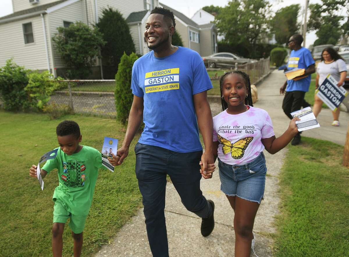 Herron Gaston campaigns door-to-door for the 23rd district senate primary with hiis godchildren Carson Cyril, 5, and Jaida Cyril, 8, on Judson Street in Bridgeport, Conn. on Friday, August 5, 2022.